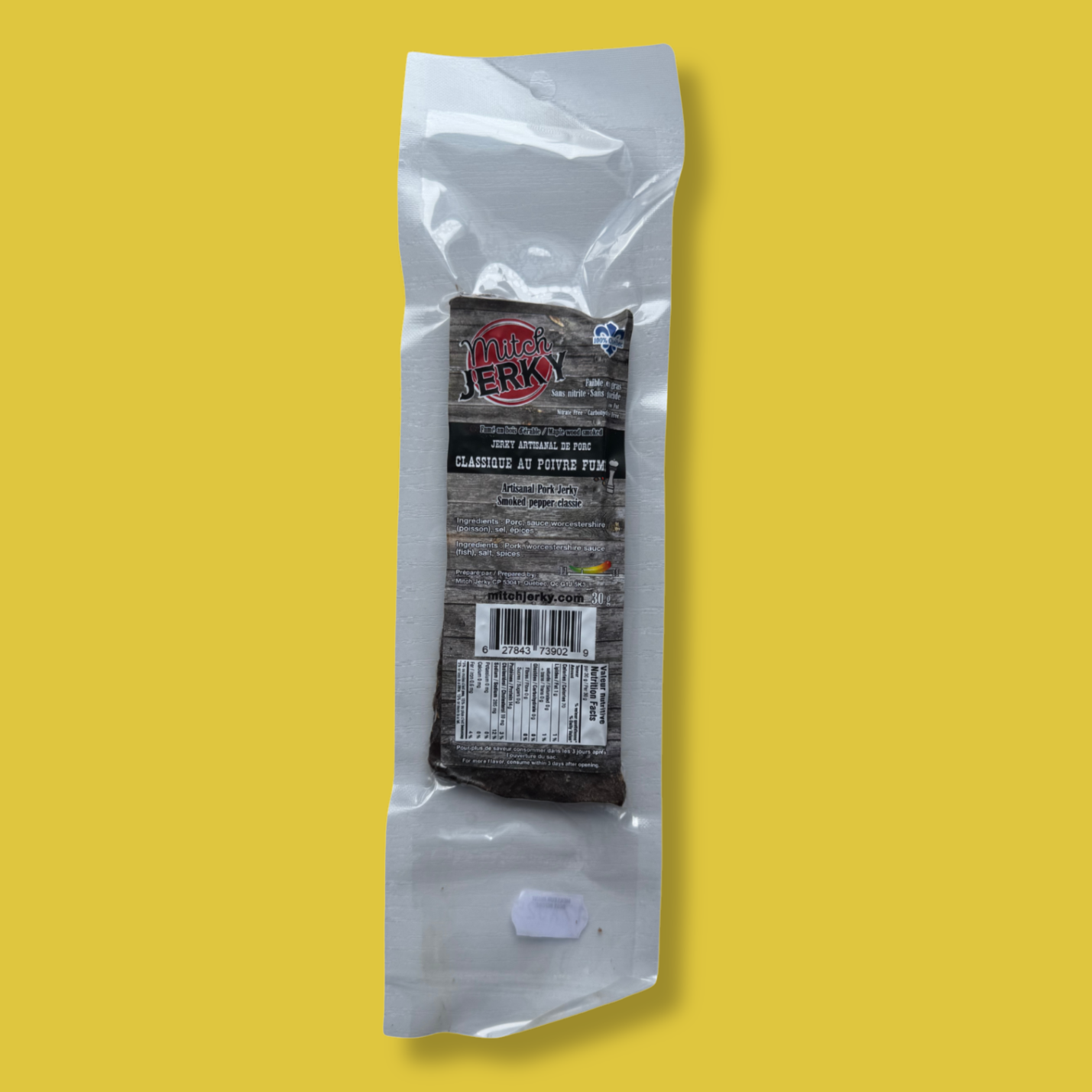 Emballage de jerky artisanal de porc Mitch Jerky, saveur classique au poivre fumé. Produit québécois sous vide avec certification Aliments du Québec. Collation riche en protéines, parfaite pour les amateurs de viande séchée et de saveurs relevées.