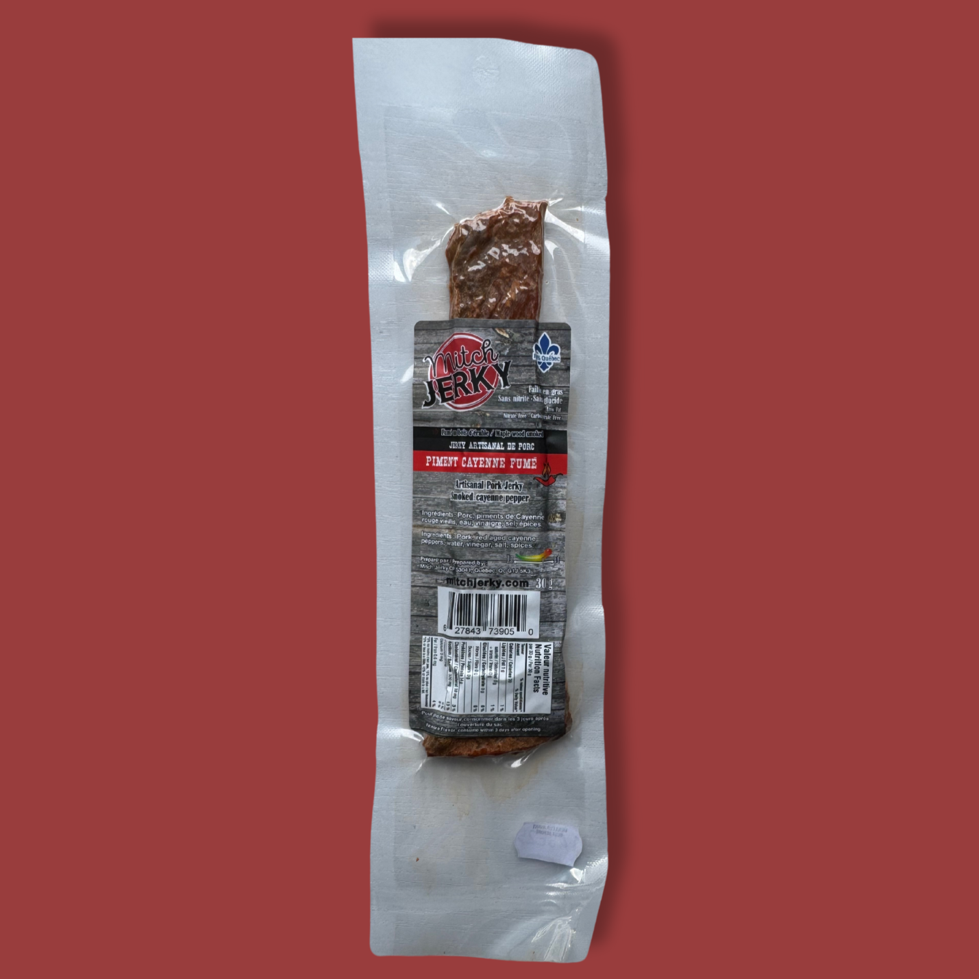 Emballage de jerky artisanal de porc Mitch Jerky, saveur piment cayenne fumé. Produit québécois sous vide avec certification Aliments du Québec. Collation riche en protéines, au goût épicé et fumé, parfaite pour les amateurs de viande séchée relevée.