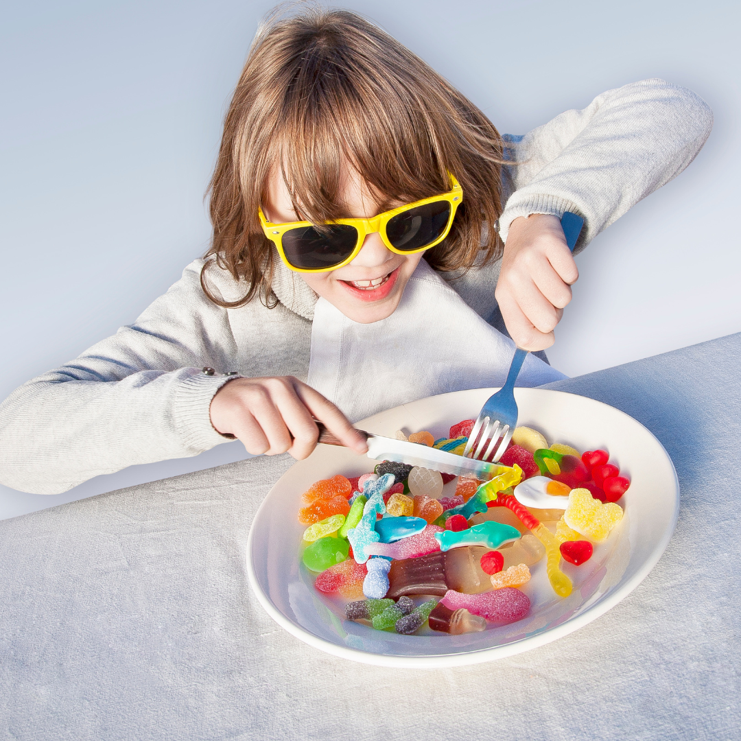 Jeune fille qui déguste une assiette de bonbons.