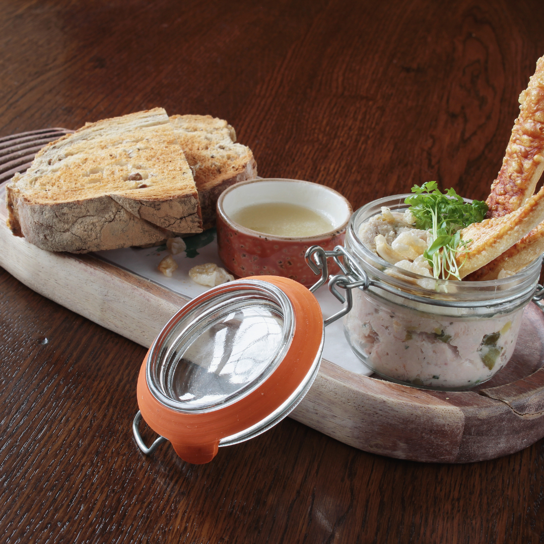 Pain sur planche avec pot de terrine de canard. 