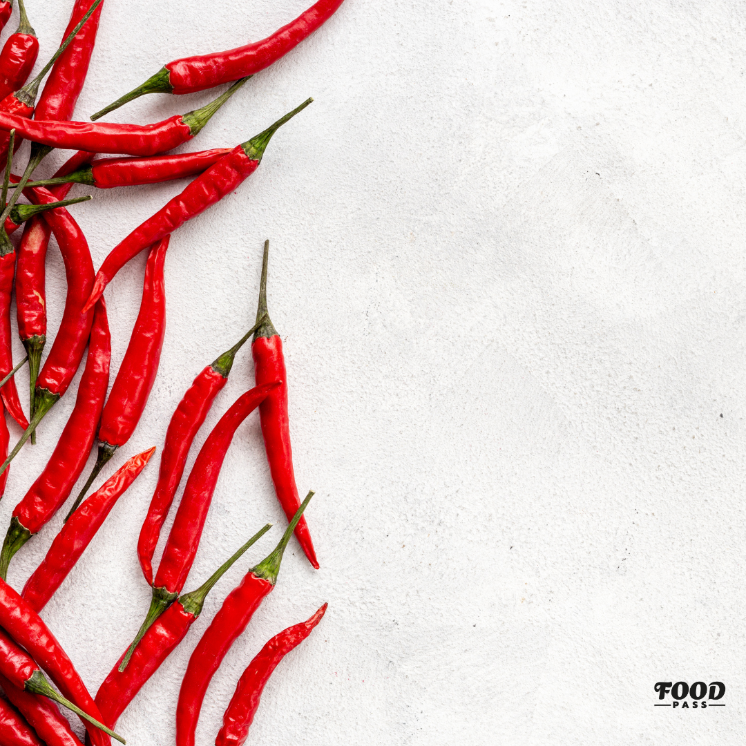 Piments rouges frais disposés sur un fond clair, mettant en avant l’ingrédient principal des sauces piquantes de La Sauce MTL. Image utilisée pour le blogue FoodPass de février.